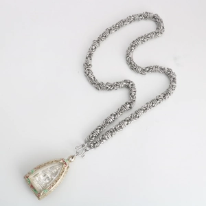 Detailed silver dragon scale chain with ornate Thai Buddhist amulet featuring red green accents