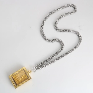 Detailed close-up of a silver braided stainless steel chain with a gold Buddha pendant