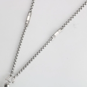 Detail of stainless steel box chain with cylindrical accents and secure S-hook clasp