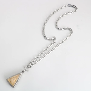 Detail of a carved triangular Buddha pendant on a stainless steel square box chain