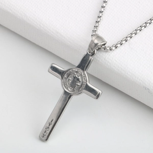 Macro detail of silver Saint Benedict cross pendant with Italy engraving and box chain