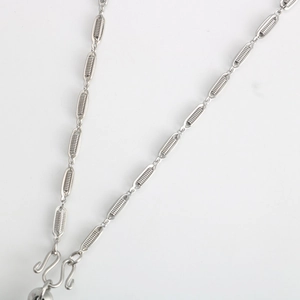 Macro shot of silver stainless steel lantern chain with intricate spiral wire fill and W-hook