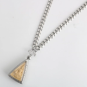 Detail view of a silver stainless steel Buddhist pendant necklace with vintage carving