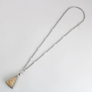 Detailed macro shot of silver snake chain with triangular Thai Buddha amulet pendant
