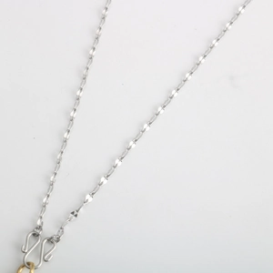 Close-up of silver twist chain necklace with gold ring and S-shaped hook fasteners