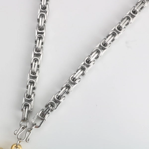 Detailed close-up of silver Byzantine style stainless steel chain with secure S-hook clasp