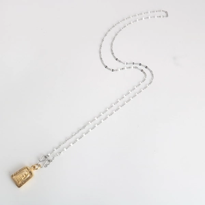 Detail of Thai Buddha amulet pendant with gold finish and silver stainless steel chain