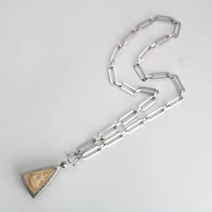 Dettaglio della collana buddista in acciaio inossidabile con ciondolo amuleto triangolare