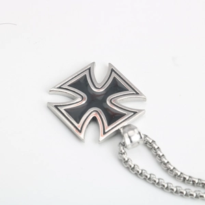 Détail macro du pendentif croix de fer en acier inoxydable avec émail noir rétro