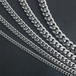 Détail de cinq largeurs de chaînes cubaines argentées sur cuir noir texturé