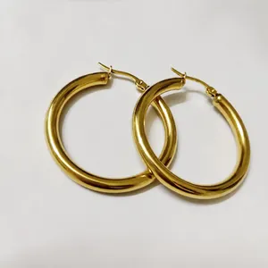Detailed view of large 4mm thick hollow tube gold hoop earrings with secure clasp