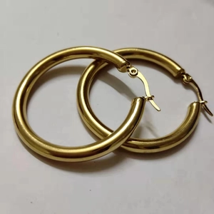 Detail of 4mm hollow tube gold hoop earrings with polished finish and needle closure