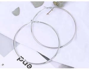 Macro detail of polished 316L stainless steel large hoop earrings with snap closure