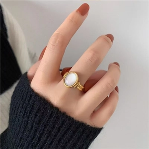 Minimalist 18K gold plated oval white shell ring with ribbed band on finger