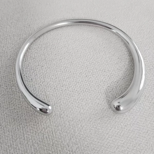 Détail du collier choker argenté poli avec des extrémités en forme de goutte d'eau