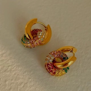 Detalle de pendientes de aro en acero inoxidable de 18K con cristales de colores