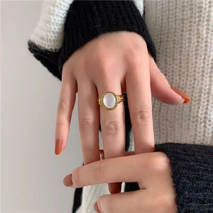 Macro detail of vintage gold ring with white shell inlay and twisted textured band