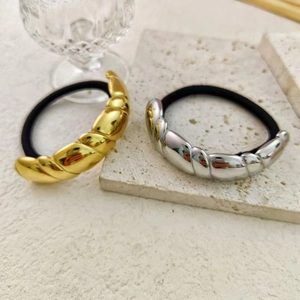 Minimalistische Haargummis mit 18K Gold und Silber Spiral-Metall auf weißem Marmor