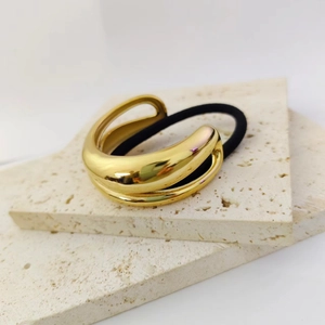 Modern 18K gold-plated double-layer elastic hair tie on a white stone background