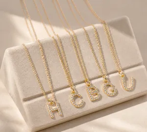 Close-up of gold alphabet pendant necklaces with sparkling zircon inlay on fine link chains