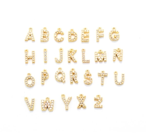 Close-up of A-Z gold alphabet pendants with paved crystals for DIY jewelry necklaces