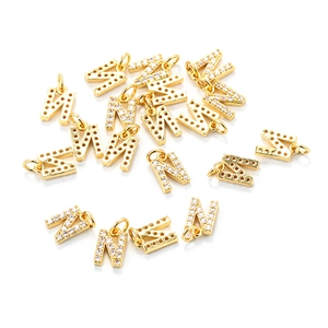 Macro shot of gold letter N pendants with cubic zirconia for DIY necklace jewelry