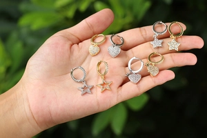 Dettaglio degli orecchini a cuore e stella placcati in oro con zirconi cubici incastonati