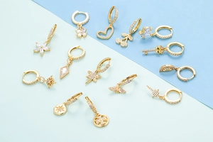 Collezione di orecchini dorati con ciondoli in zirconia a cuore, stella e farfalla