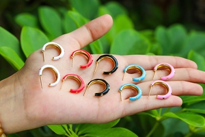 Détail des créoles en émail en forme de C en cinq couleurs acidulées avec touches dorées