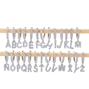 Silberne Creolen mit funkelnden A-Z Kristall-Buchstabenanhängern auf Holzständer