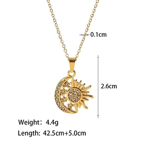 Detail of gold moon and sun pendant necklace with sparkling cubic zirconia on white backdrop