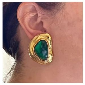 Macro shot of vintage gold lava texture earrings with emerald green resin inlay