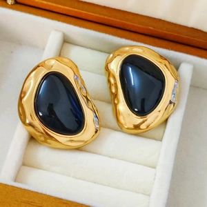 Retro stainless steel gold-plated earrings with large dark resin stones in a jewelry box
