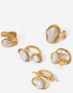 Detail van een 5-delige set goudkleurige ringen met barokke parels voor dames, chic