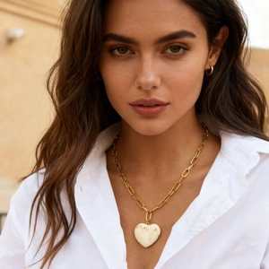 Close-up of 18K gold stainless steel chunky paperclip chain with white resin heart pendant