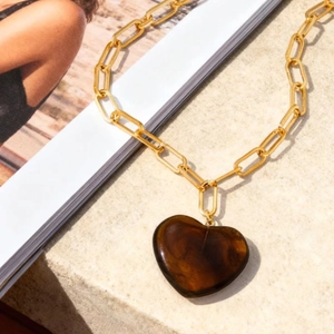 Close-up of heart-shaped tortoiseshell resin pendant on 18K gold stainless steel chain