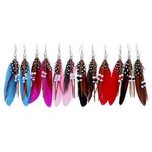 Detail of colorful bohemian feather earrings with beads and fringe in a 6-pair set