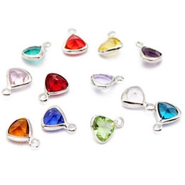 Detailed view of colorful triangle crystal pendants with silver metal frames for DIY jewelry