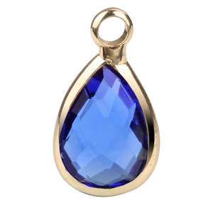Detail of a pear-shaped dark blue faceted glass birthstone pendant with gold plated rim
