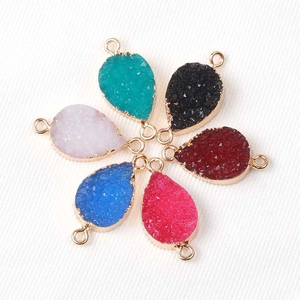 Detalle de dijes de resina druzy en forma de gota con baño de oro y anillos dobles para DIY