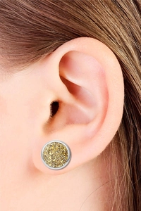 Gros plan d'une boucle d'oreille ronde en druzy avec bord argenté et texture dorée