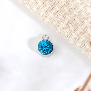 Dettaglio di un ciondolo portafortuna blu da 6mm con base in metallo argentato