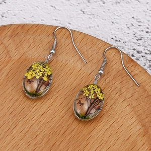 Bohemian silver drop earrings with oval resin pendants featuring real dried yellow flowers