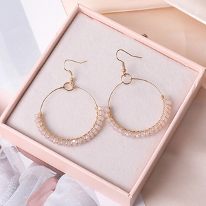 Details von rosa Perlenohrringen mit Golddrahtbügeln in einer eleganten Geschenkbox
