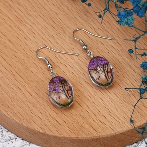 Bohemian silver earrings with oval resin pendants featuring tree and butterfly nature scenery