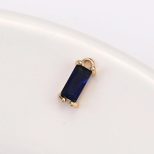Detailed macro view of a rectangular dark blue crystal pendant with gold claw setting