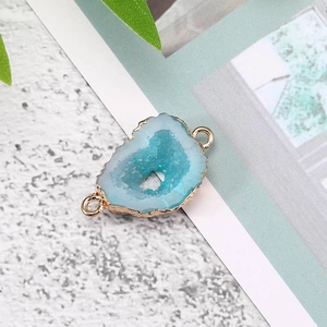 Detail van blauwe hars geode hanger met vergulde randen en dubbele metalen connectoren