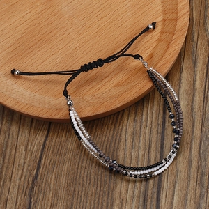 Détail du bracelet bohème fait main multicouche avec cordon noir tressé et perles colorées