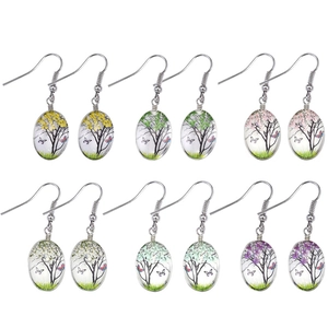 Detail of six pairs of handmade glass drop earrings with butterfly and tree motifs