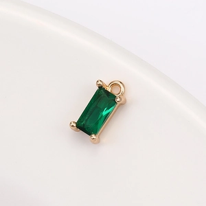 Macro shot of rectangular emerald green crystal pendant with gold claw setting